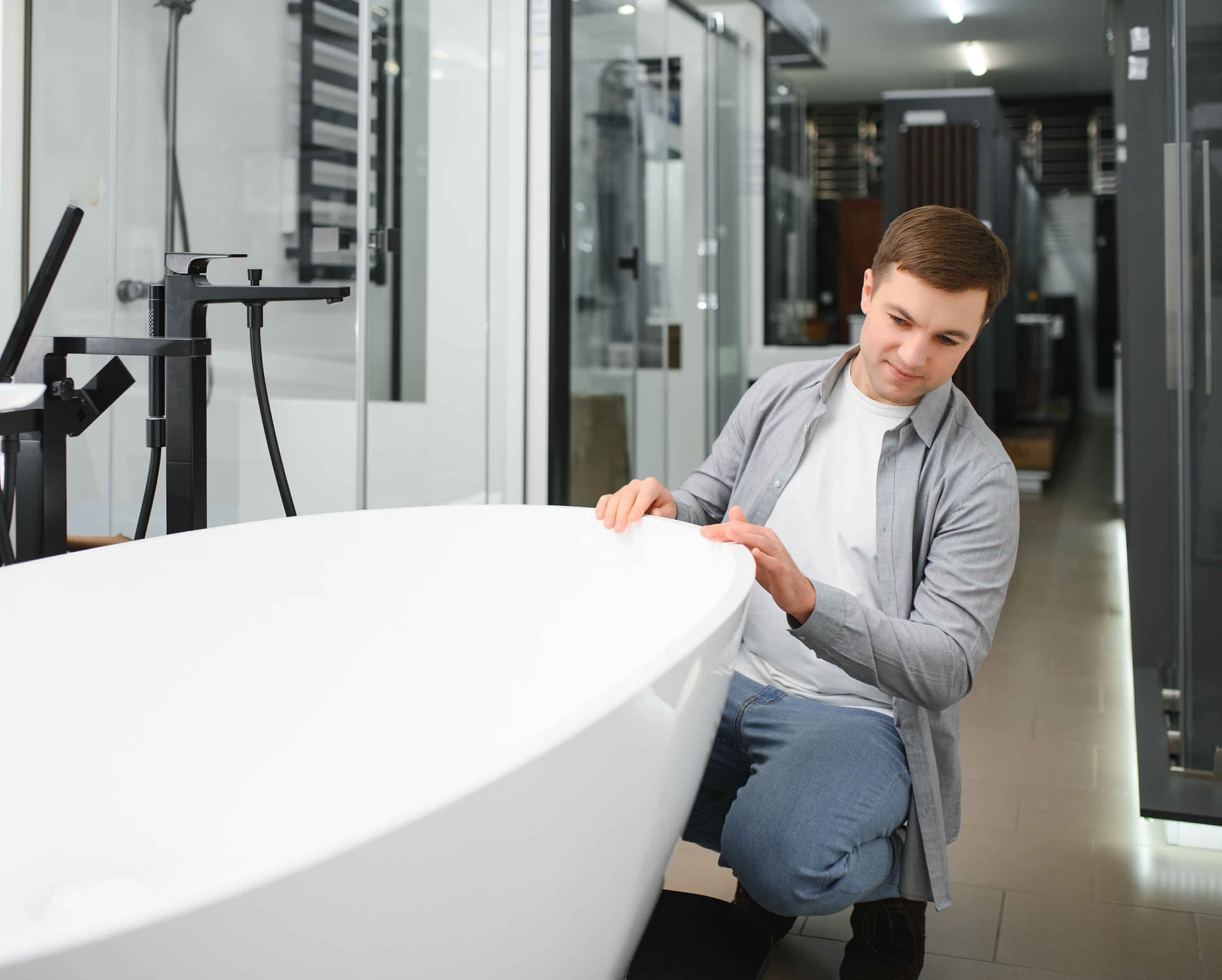 man-customer-choosing-ceramic-bath-in-bathroom,jpg
