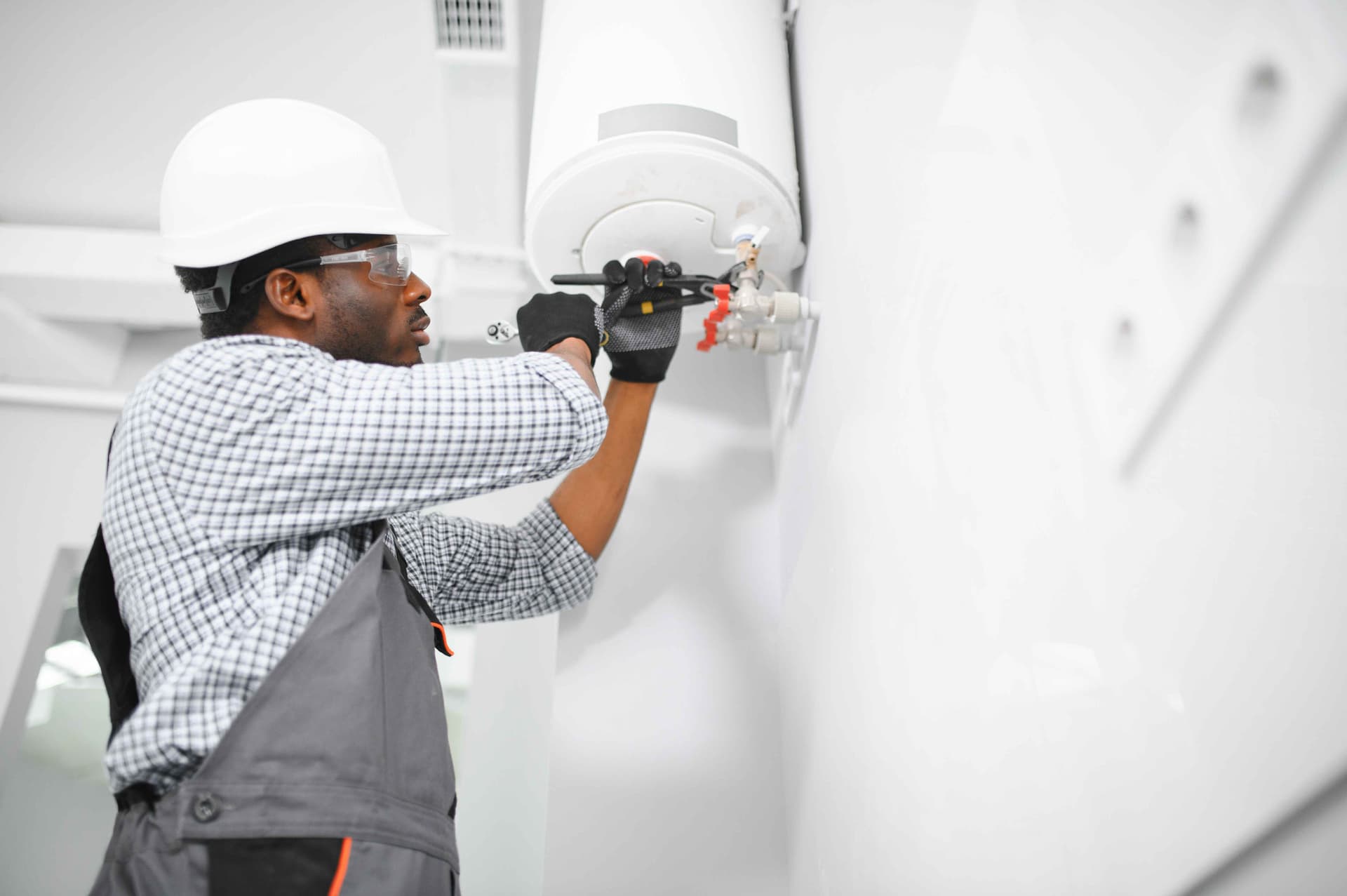 young-african-male-plumber-repairing-boiler,jpg