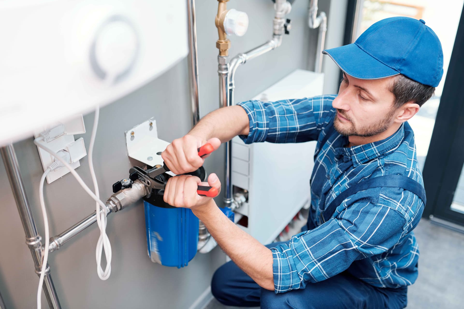 young-man-in-workwear-using-pliers-while-installing,jpg
